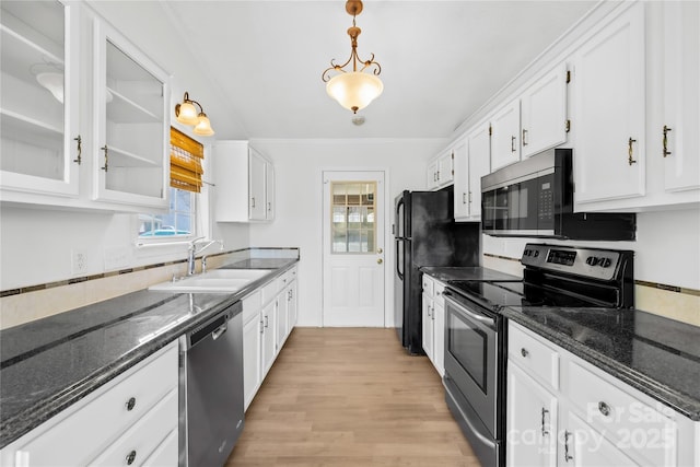 kitchen featuring stainless steel appliances, white cabinets, a sink, and dark stone countertops