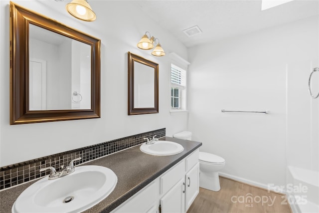 full bath featuring visible vents, a sink, toilet, and double vanity