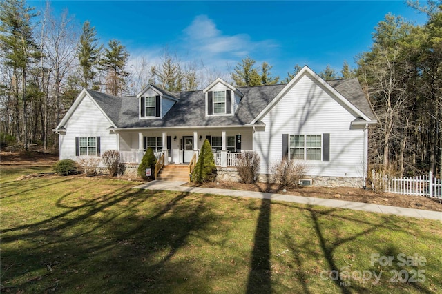 new england style home with a porch, a front yard, and fence