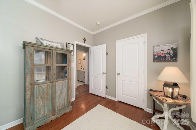 interior space featuring crown molding, baseboards, and wood finished floors