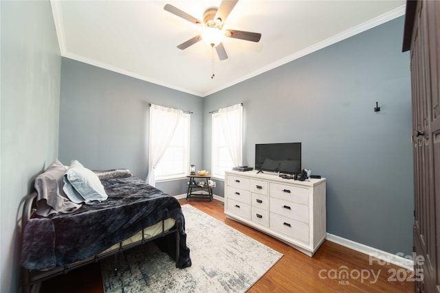 bedroom featuring light wood-style flooring, baseboards, and crown molding