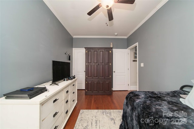 bedroom featuring ornamental molding, dark wood finished floors, and a ceiling fan