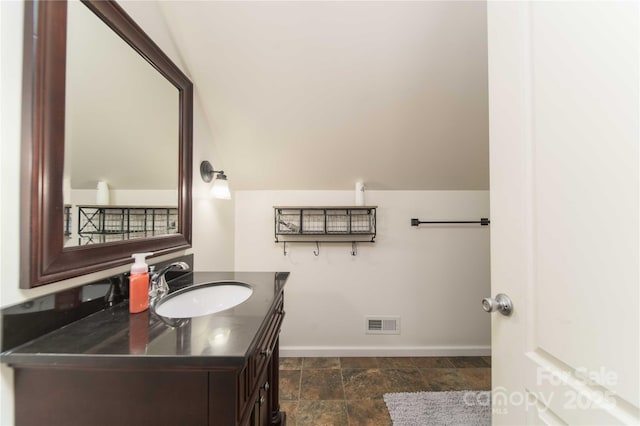 bathroom featuring stone finish floor, baseboards, visible vents, and vanity