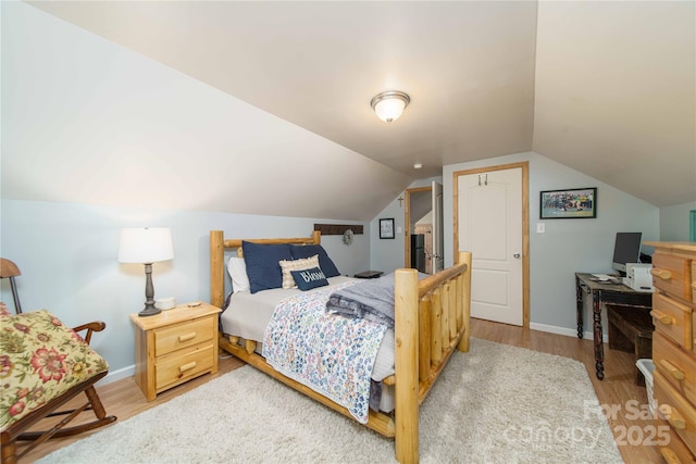 bedroom featuring vaulted ceiling, baseboards, and wood finished floors