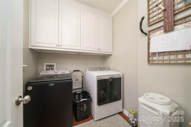 clothes washing area with cabinet space and independent washer and dryer