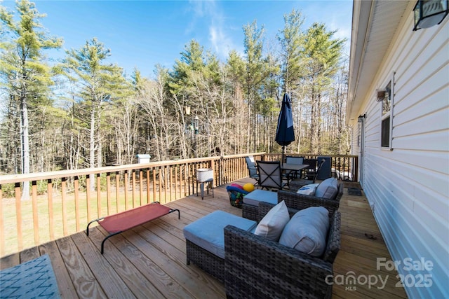 wooden terrace with outdoor dining area and an outdoor living space