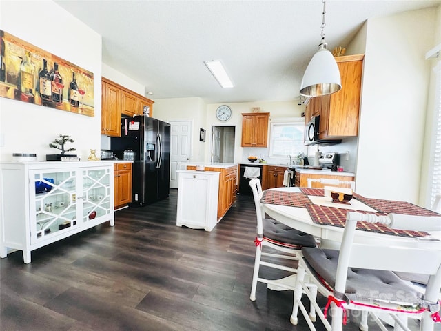 kitchen with a kitchen island, light countertops, brown cabinets, black appliances, and dark wood finished floors