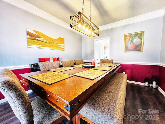 dining area with baseboards, crown molding, and wood finished floors