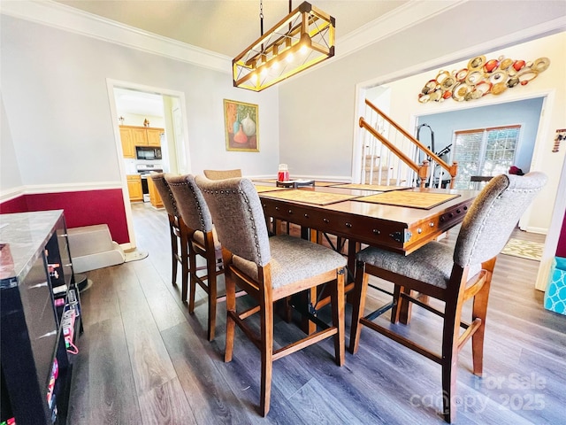 dining space with dark wood-type flooring and crown molding