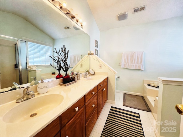 bathroom with a bath, visible vents, a sink, and tile patterned floors