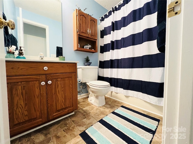 full bath featuring a textured ceiling, a shower with shower curtain, vanity, and toilet