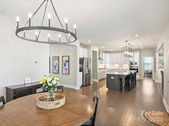 dining room with an inviting chandelier, recessed lighting, baseboards, and dark wood-type flooring