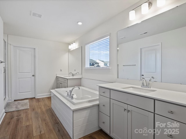 bathroom with a sink, visible vents, and wood finished floors