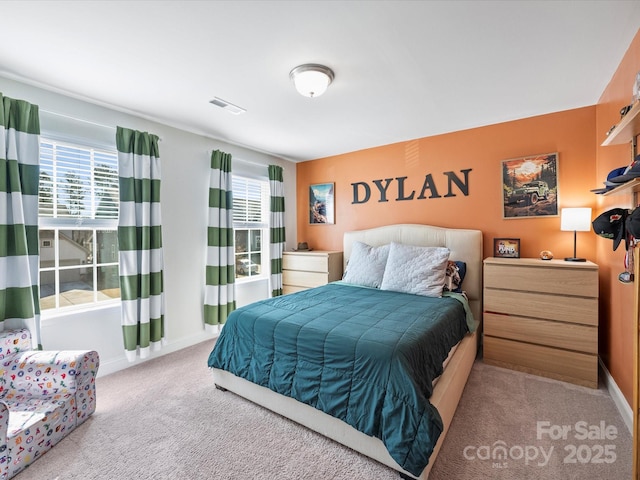carpeted bedroom with visible vents and baseboards