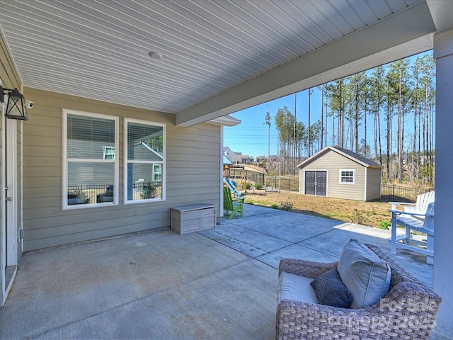 view of patio / terrace with an outbuilding and fence