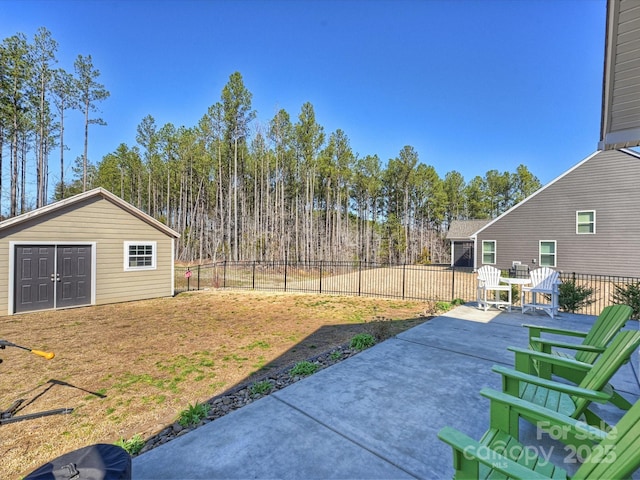 view of yard with a patio area, an outbuilding, and a fenced backyard