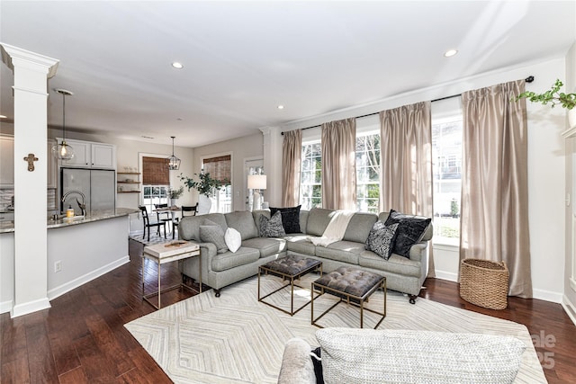 living room with recessed lighting, baseboards, dark wood-type flooring, and ornate columns