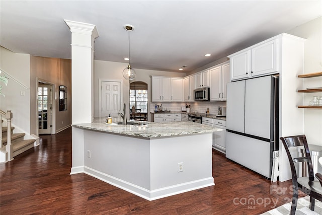 kitchen featuring a sink, stainless steel appliances, decorative backsplash, light stone countertops, and dark wood-style flooring