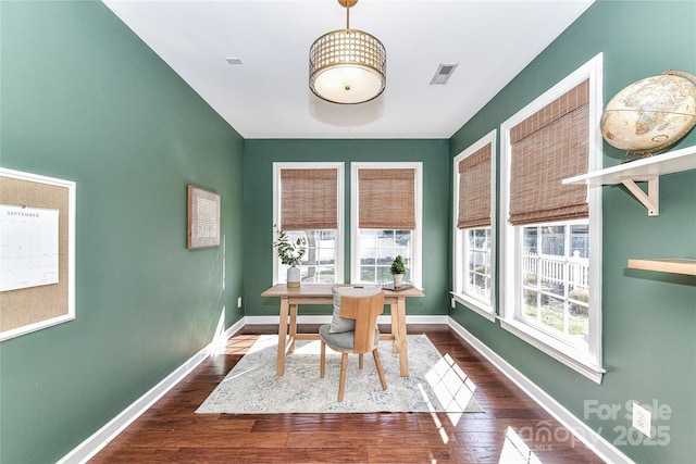 dining space with baseboards, dark wood-type flooring, and a healthy amount of sunlight