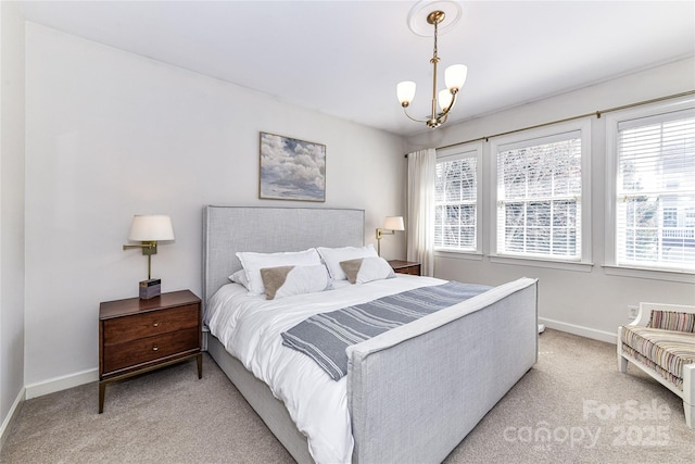 bedroom with a chandelier, light colored carpet, and baseboards