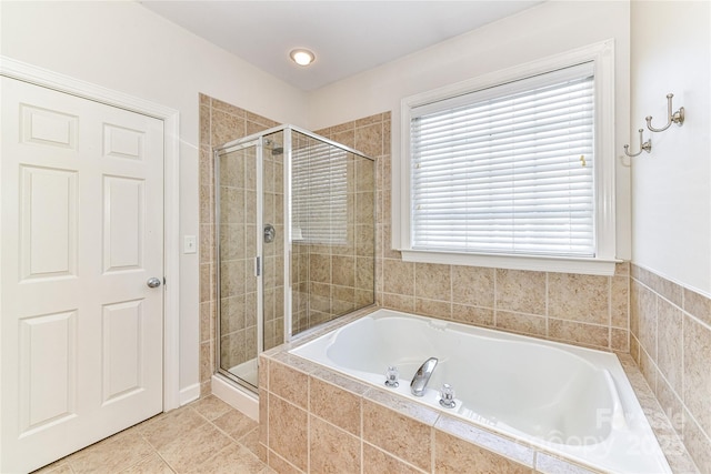 bathroom featuring tile patterned flooring, a bath, and a stall shower