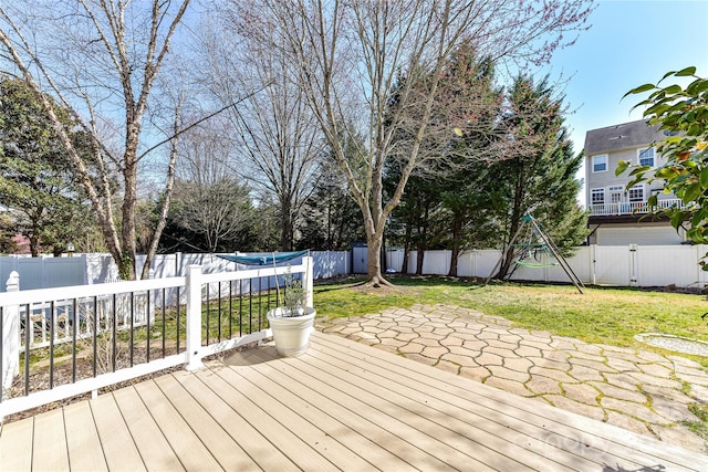 wooden terrace featuring a patio area, a lawn, and a fenced backyard