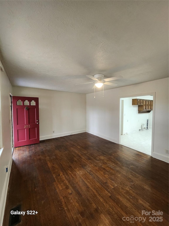 unfurnished living room featuring ceiling fan, a textured ceiling, baseboards, and hardwood / wood-style flooring