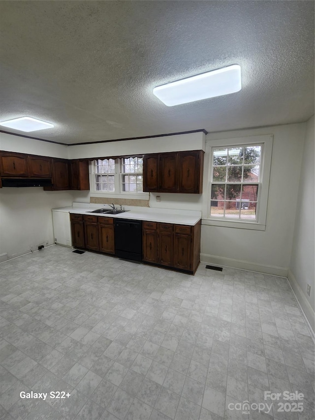 kitchen featuring dark brown cabinetry, black dishwasher, visible vents, and light countertops