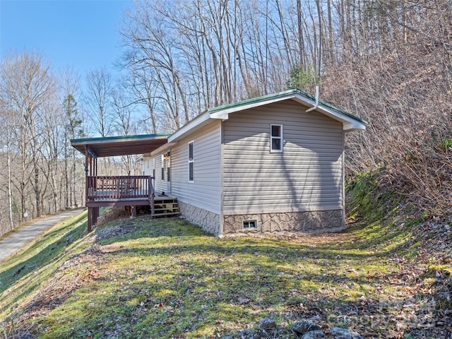 view of side of property featuring a wooden deck and a yard