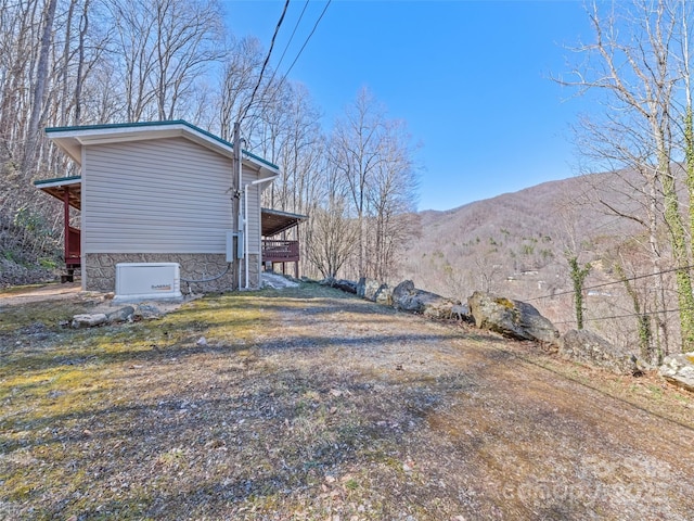 view of side of home with stone siding and a mountain view