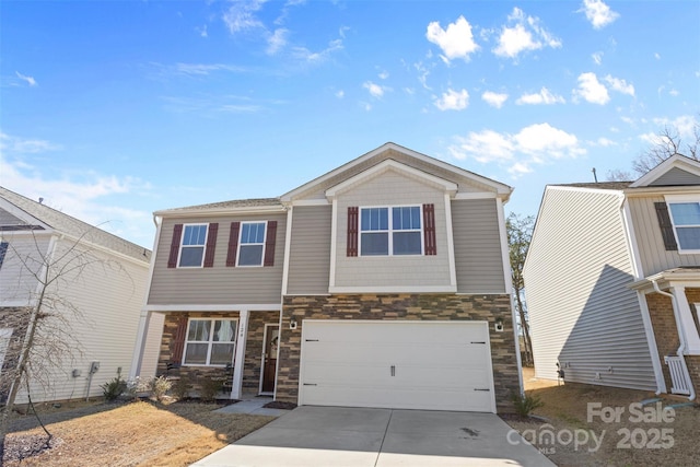 view of front of home featuring a garage, stone siding, and driveway