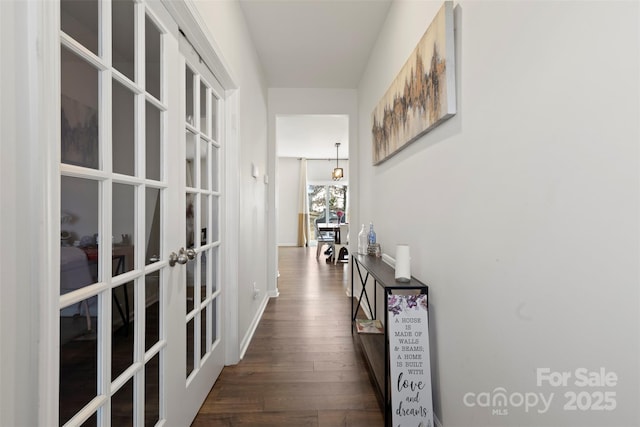 hallway featuring french doors, dark wood-type flooring, and baseboards