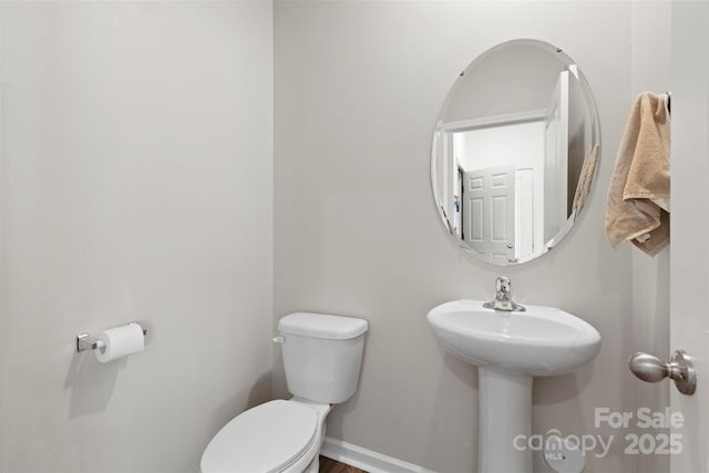 bathroom featuring baseboards and toilet