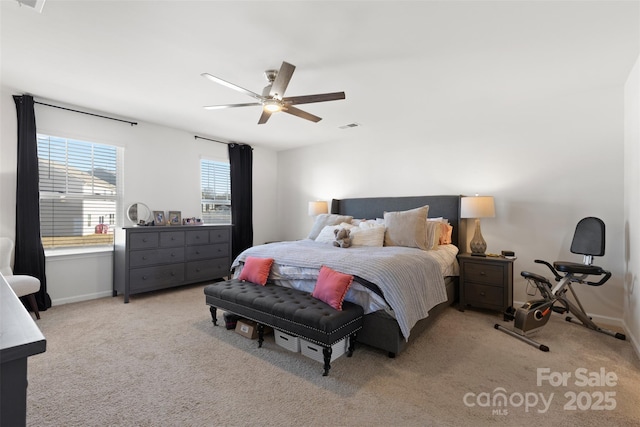 bedroom with visible vents, light carpet, baseboards, and a ceiling fan