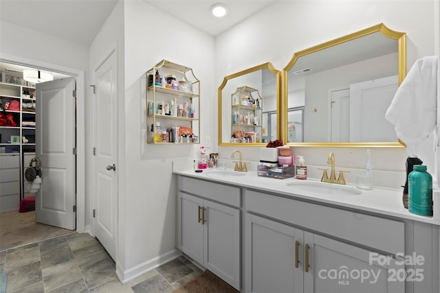 full bath featuring double vanity, stone finish flooring, visible vents, and a sink