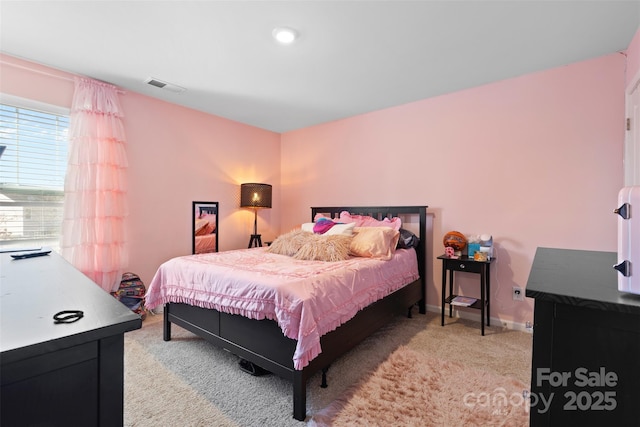 bedroom featuring light colored carpet, visible vents, and baseboards