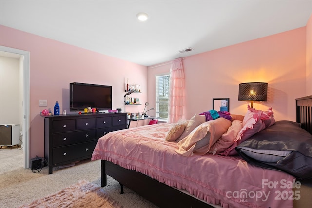 bedroom featuring visible vents and light carpet