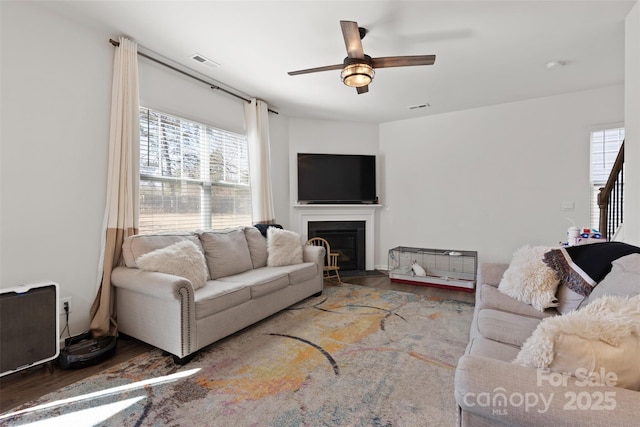 living area featuring visible vents, a healthy amount of sunlight, and wood finished floors