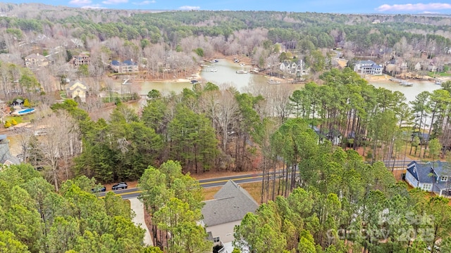 aerial view featuring a wooded view and a water view