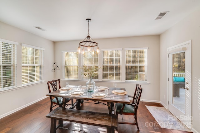 dining space with dark wood-style floors, visible vents, and plenty of natural light