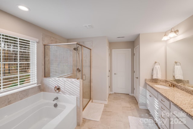 full bathroom featuring vanity, a shower stall, a garden tub, and baseboards