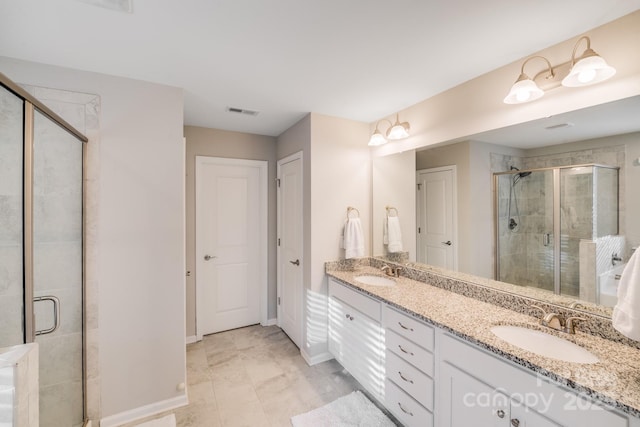 full bath with double vanity, visible vents, a stall shower, and a sink