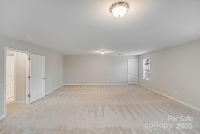 empty room with light colored carpet and baseboards