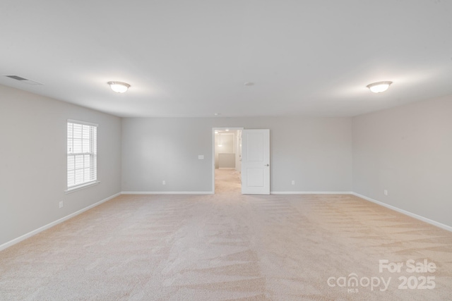 spare room featuring visible vents, baseboards, and light colored carpet