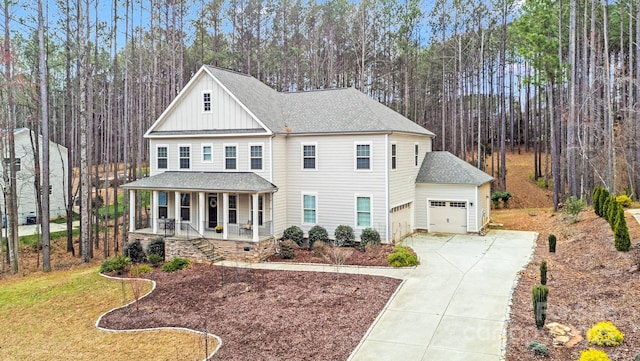 view of front facade with board and batten siding, covered porch, concrete driveway, an attached garage, and roof with shingles