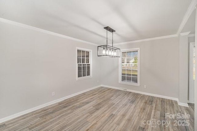 unfurnished dining area featuring ornamental molding, baseboards, and wood finished floors