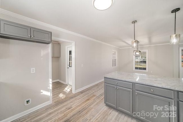 kitchen featuring light wood-style flooring, baseboards, crown molding, and gray cabinetry