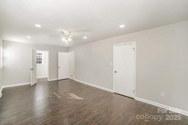 empty room with baseboards, wood finished floors, and recessed lighting