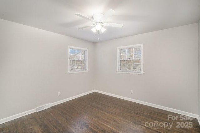 spare room with ceiling fan, baseboards, dark wood finished floors, and a wealth of natural light