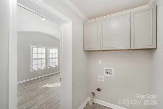 laundry area featuring washer hookup, crown molding, cabinet space, wood finished floors, and baseboards